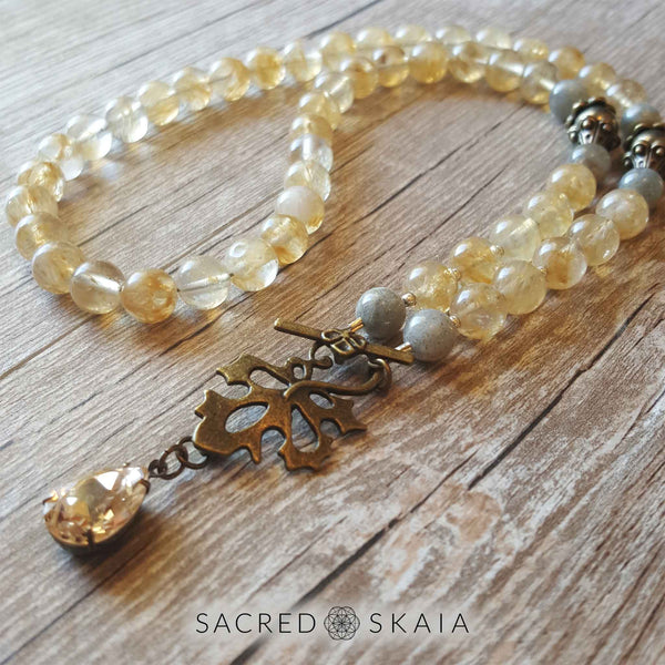 Crystals for abundance include citrine, pyrite and labradorite in the Abundant Success Half Mala from Sacred Skaia. It has 54 beads and a famous name pear-shaped crystal dangling from a bronze leaf toggle clasp.