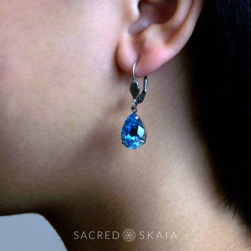 Aphrodite Crystal Teardrop Earrings with oxidized silver settings, lever back ear wires and pear-shaped aquamarine Swarovski crystals, shown on a model with pierced ears