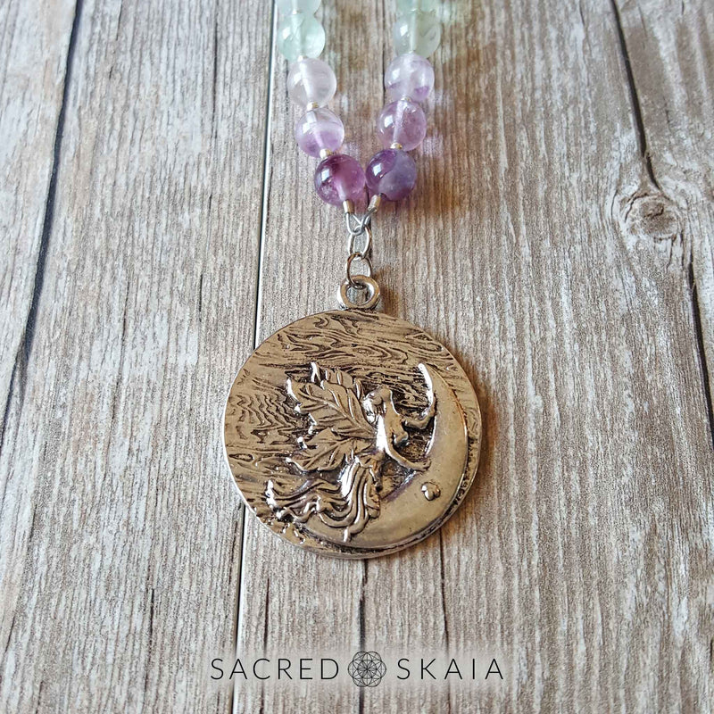 Silver moon fairy pendant closeup. Crystals for anxiety included in the Emotional Freedom Mala by Sacred Skaia are amethyst, fluorite, clear quartz and labradorite or sandalwood. Also for use with EFT healing.
