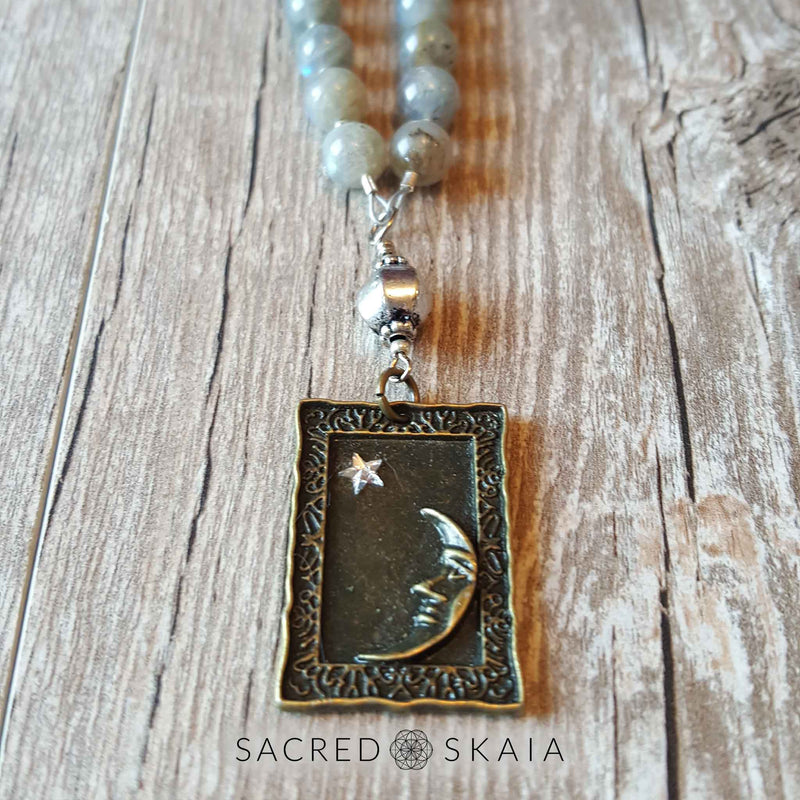 Closeup of Man in the Moon bronze pendant. Crystals for abundance included in the Magical Abundance Mala by Sacred Skaia are citrine, labradorite, pyrite and sandalwood.